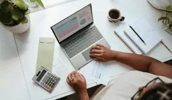 Mulher acessando gráficos e métricas no notebook