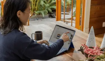 Mulher tocando a tela de um laptop